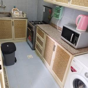 uma pequena cozinha com fogão e micro-ondas em العين الهيلي مصباح ب1 em Al Ain