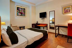 Habitación de hotel con cama, escritorio y espejo. en Townhouse 1339 Hotel Anamika Enclave en Gurgaon
