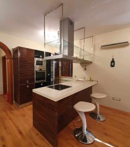 a kitchen with a sink and two stools in it at Apartman NEDA in Jablanac +24 photos