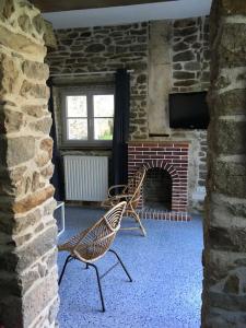two chairs sitting in a room with a brick fireplace at Le Récif, maison indépendante Corniche de la mer in Concarneau