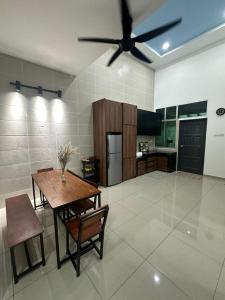 sala de estar con mesa y ventilador de techo en Eco Homestay Ipoh, en Simpang Pulai