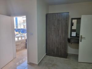 pasillo con armario de madera y ventana en Hospitality apartments, en Wadi Musa