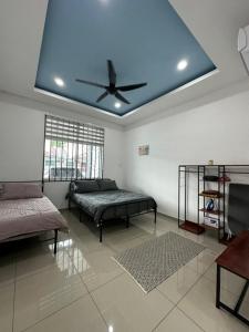 Habitación con 2 camas y ventilador de techo. en Eco Homestay Ipoh, en Simpang Pulai