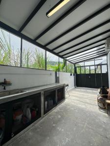 een grote open garage met een tafel en ramen bij Eco Homestay Ipoh in Simpang Pulai