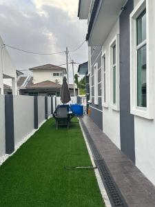 un pequeño patio trasero con césped junto a una casa en Eco Homestay Ipoh, en Simpang Pulai