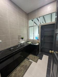 baño con encimera negra y ventana en Eco Homestay Ipoh, en Simpang Pulai