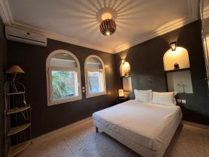 1 dormitorio con 1 cama blanca y 2 ventanas en DreamCatcher Homes en Mirleft