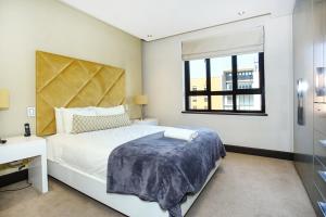 a bedroom with a large bed and a window at Melrose Arch Luxury Apartment - WITH GENERATOR in Johannesburg +20 photos