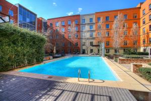 a large swimming pool in front of a building at Melrose Arch Luxury Apartment - WITH GENERATOR in Johannesburg