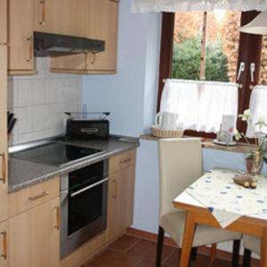 a kitchen with a stove and a table and a window at Fewo Leopold - Ferienwohnung 1 in Cuxhaven