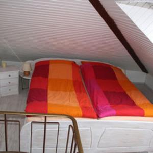 a bed with a colorful blanket on top of it at Fewo Leopold - Ferienwohnung 1 in Cuxhaven
