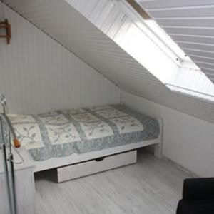 a small bed in a room with a window at Fewo Leopold - Ferienwohnung 1 in Cuxhaven