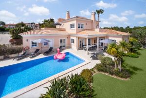 eine Luftansicht eines Hauses mit Pool in der Unterkunft Extraordinary Villa on an elevated position in Quinta do Lago in Quinta do Lago