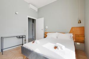 - une chambre avec un grand lit blanc et des serviettes dans l'établissement Brera Apartments in Porta Ticinese, à Milan