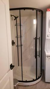 a shower with a glass door in a bathroom at Cozy home on a quiet street minutes to DT Kingston in Kingston