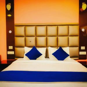 ein Schlafzimmer mit einem Bett mit blauen Kissen in der Unterkunft HOTEL CRORE GRAND BHARAT STAY in Neu-Delhi