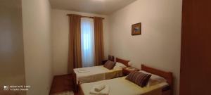 a small room with two beds and a window at Studio Apartment Lile in Trstenik