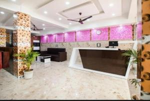 eine Lobby mit einem großen Sofa und rosa Wänden in der Unterkunft HOTEL CRORE GRAND BHARAT STAY in Neu-Delhi