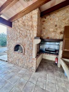 a stone wall with a fireplace in a patio at Finca Son Manxo (villas2meet Mallorca) in Manacor