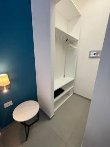 ein kleines weißes Zimmer mit einem Tisch und einem Schrank in der Unterkunft Casa e Bottega in Manfredonia