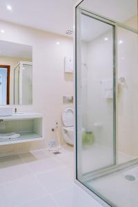 a bathroom with a glass shower and a toilet at Beira Terrace Hotel in Beira