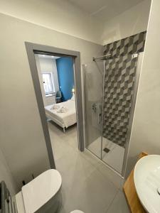 ein Bad mit einer Dusche, einem WC und einem Bett in der Unterkunft Casa e Bottega in Manfredonia