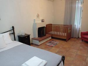 een slaapkamer met een bed, een wieg en een open haard bij Marina Traditional Stonehouse in Afétai