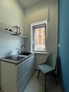 eine kleine Küche mit Spüle und Stuhl in der Unterkunft Casa e Bottega in Manfredonia + 14 Fotos