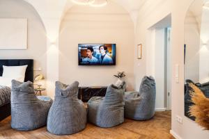 ein Wohnzimmer mit vier grauen Ottomanen in der Unterkunft NEW LUXUS Suite I TWO Kingbeds I Center I Netflix in Augsburg