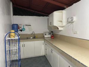a kitchen with white cabinets and a sink at KlentFloyd Room Rentals in Dauin