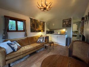uma sala de estar com um sofá e uma mesa em Pipowagen de Zwaan in Hoge Kempen nabij Maastricht em Lanaken