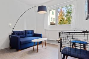ein Wohnzimmer mit einem blauen Sofa und einem Tisch in der Unterkunft Sallaz Residence by Homenhancement in Lausanne