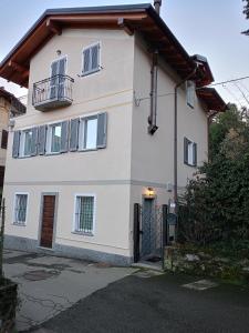 a white house with a gate in front of it at Il nido di Ele in Stresa