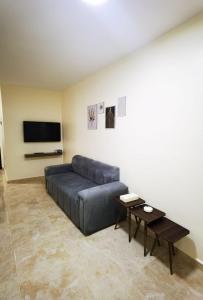 a living room with a blue couch and a tv at Hospitality apartments in Wadi Musa