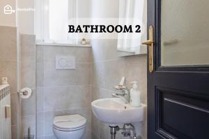 uma casa de banho com um lavatório, um WC e um espelho. em Trieste Centre - Reserved Parking & Wi-Fi em Trieste
