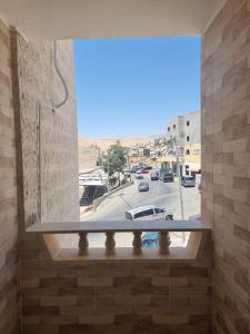 una ventana en una pared de ladrillo con vistas a la calle en Hospitality apartments, en Wadi Musa