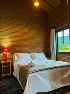 Schlafzimmer mit einem großen Bett und einem Fenster in der Unterkunft Morada da Paz in Aguas Mornas