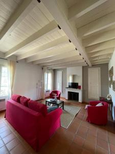 sala de estar con sofá rojo y sillas en Domaine de Cassan, en Lafare