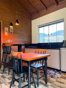 eine Küche mit einem Tisch und Stühlen im Zimmer in der Unterkunft Morada da Paz in Aguas Mornas