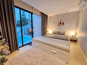 een slaapkamer met een groot bed en een groot raam bij 22Pool villa Hua-Hin in Hua Hin