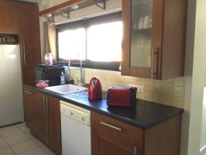 a kitchen with a sink and a red appliance on a counter at Appartement au Cœur de Ville : 6/8 personnes in Briançon