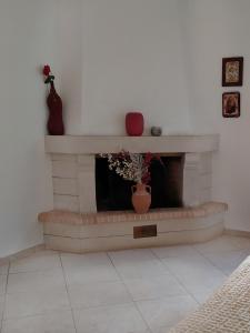 a living room with a brick fireplace with a vase at Georgia's Family Apartment in Heraklio Town