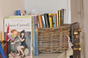 a book shelf with books and a basket of books at Sea Apartment in Sanremo