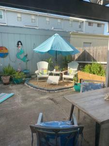 un patio con mesa, sombrilla y sillas en Beach Blanket Bungalow - A Wonderful townhome near the beach, en Galveston