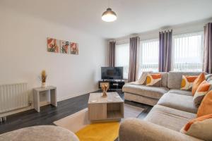 sala de estar con sofá y TV en Park View-modern 2 bed apartment en Motherwell