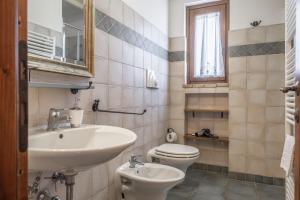 a bathroom with a sink and a toilet and a mirror at La Svolta - Aria in Manciano