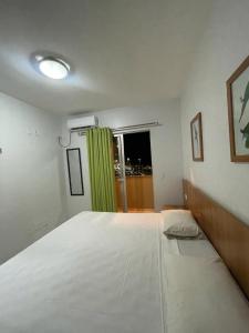 1 dormitorio con 1 cama blanca grande y ventana en Flat Golden Dolphin Grand Hotel - Quarto e Sala Com Roupa de Cama e Banho - Piscinas 24h en Caldas Novas