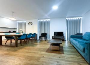 ein Wohnzimmer mit einem blauen Sofa und einem Tisch in der Unterkunft Lisboa Intendente 3Bedroom Apartment with Balcony in Lissabon