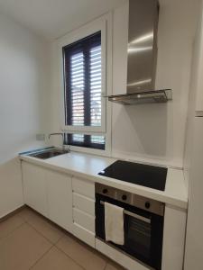 a white kitchen with a sink and a stove at Casa nel Parco in Bologna