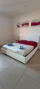 a white bedroom with a bed with red sheets at Casa nel Parco in Bologna